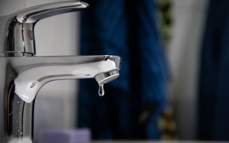 Primer plano de un grifo monomando en lo que parece un baño, en representación del proceso de arreglar un grifo que gotea.