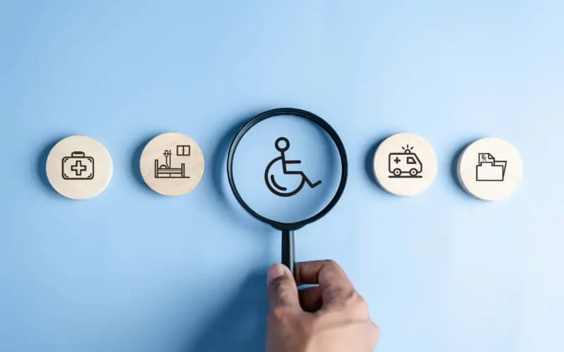 Cuatro iconos en representación de la accesibilidad cognitiva con uno destacado en el centro con una lupa, correspondiente al símbolo de persona con discapacidad.