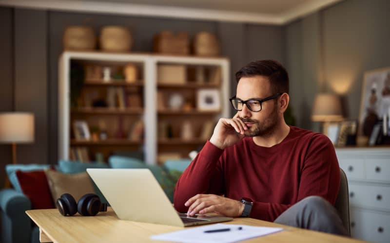 Trabajador autónomo consultando su portátil, en representación de la investigación de opciones de seguro de salud para autónomos.