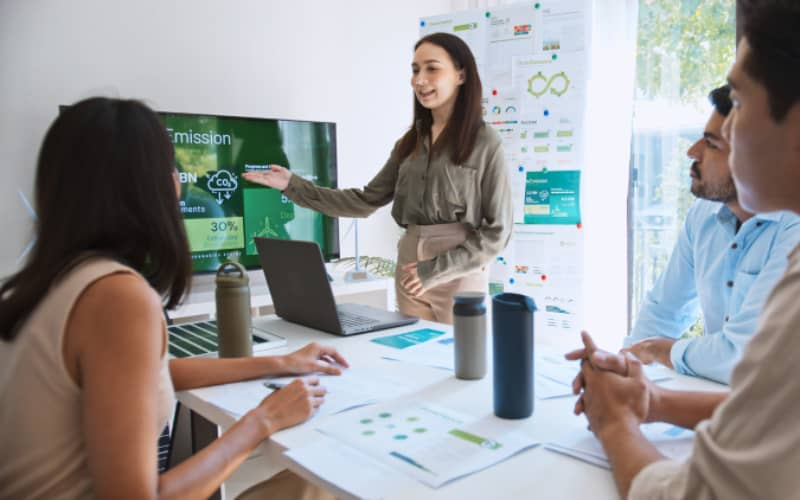 Profesionales en reunión de empresa con documentos de sostenibilidad sobre la mesa, en representación de qué es ESG