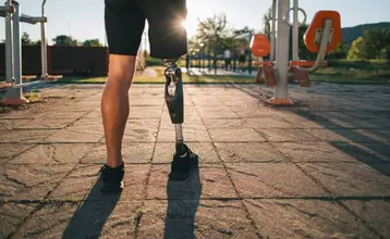 diversidad-funcional-o-discapacidad-00.jpg Persona con prótesis en una pierna caminando en un parque deportivo al aire libre, al atardecer. Representa un ejemplo de diversidad funcional o discapacidad motriz.